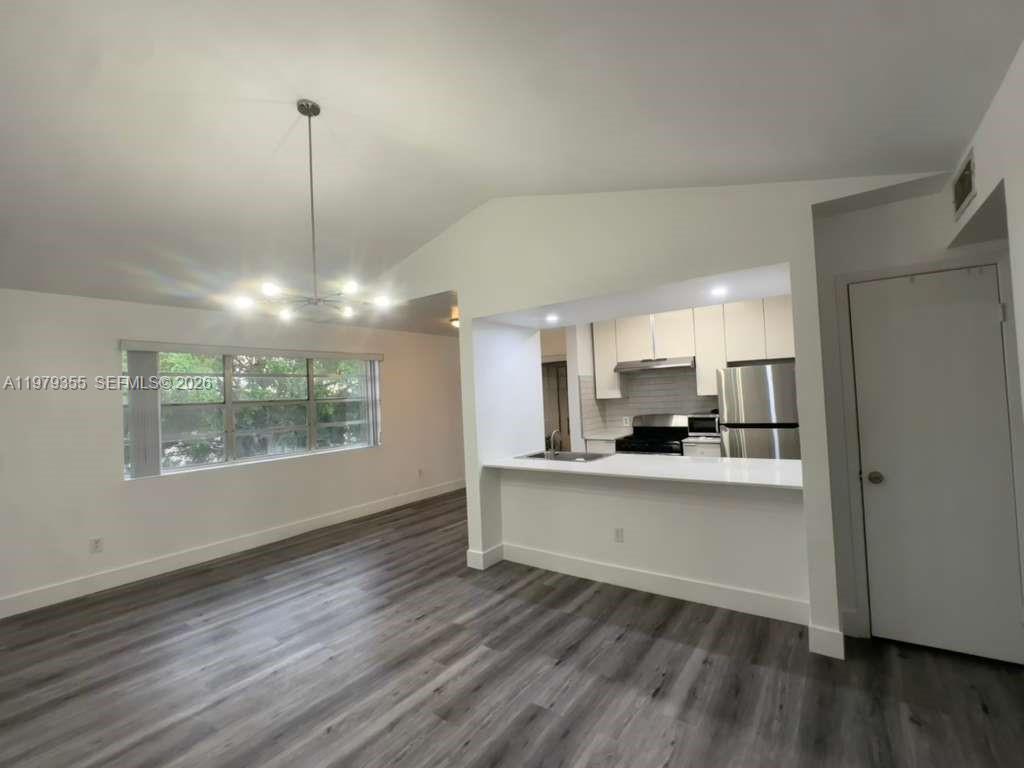 15330 Southwest 106th Terrace, Unit 915 Miami, FL 33196 - Photo 1 of 8 a view of a kitchen with a sink wooden floor kitchen view and a window