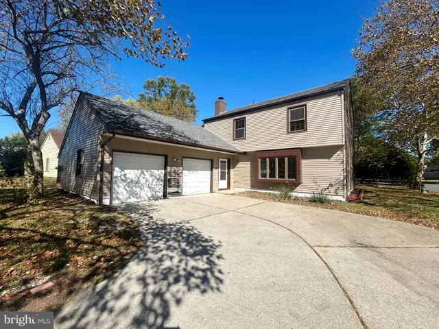 a front view of a house with a snow on the road