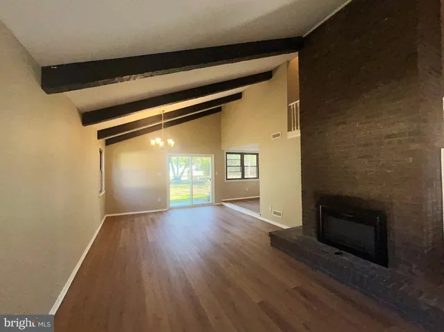 a view of empty room with window and wooden floor