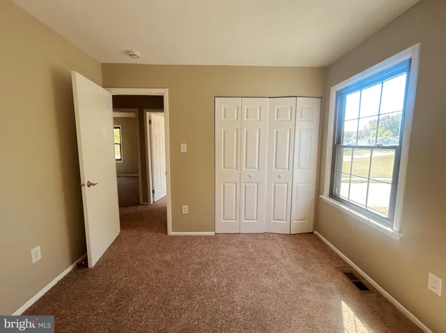 an empty room with windows and closet
