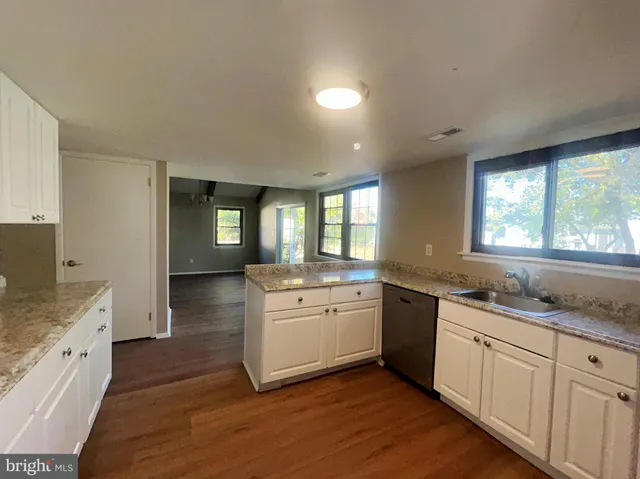 a large kitchen with lot of cabinets and wooden floor