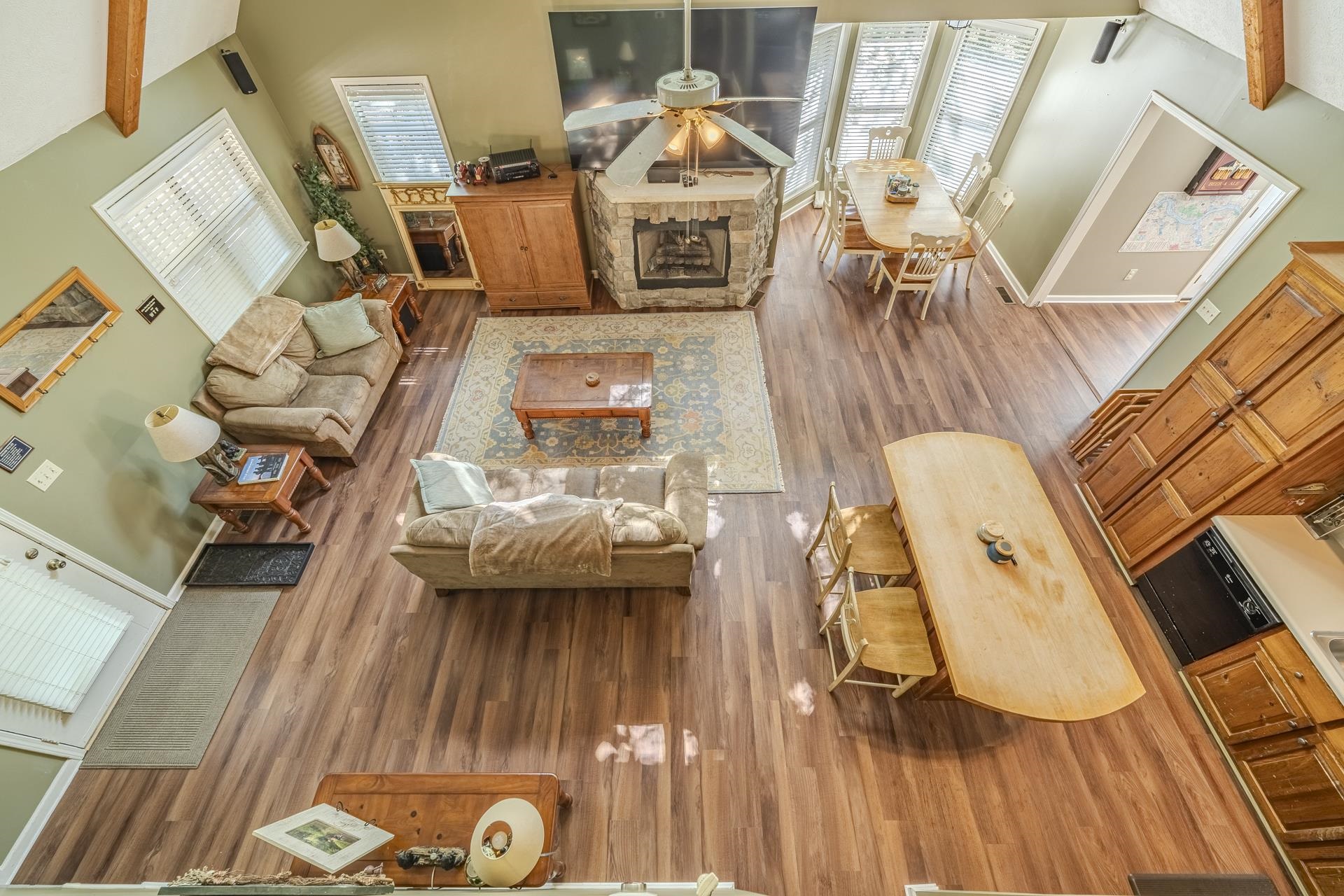 435 Murray Lane Counce, TN 38326 - Photo 25 of 34 Spacious living area featuring wood-finish flooring, a stone fireplace, and exposed wood beams