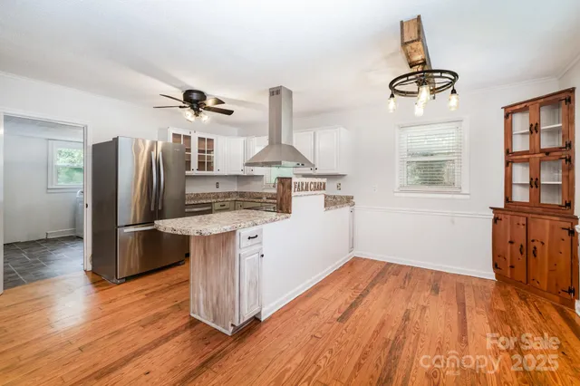 a kitchen with stainless steel appliances granite countertop a refrigerator and a stove top oven