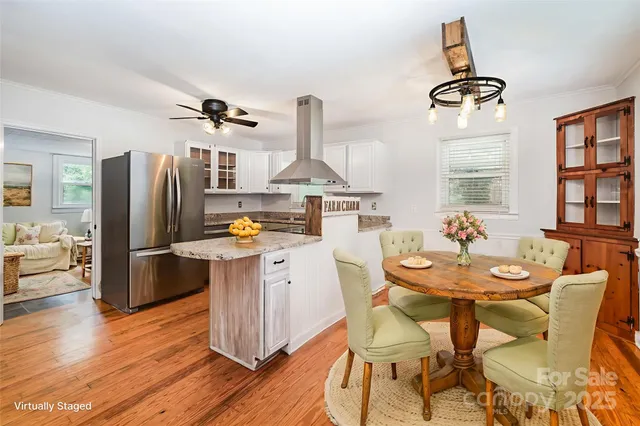 a kitchen with stainless steel appliances granite countertop a stove refrigerator and dining table