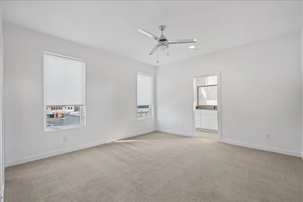 an empty room with a ceiling fan and a window