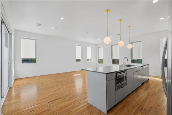 a kitchen with stainless steel appliances granite countertop a stove and a wooden floors