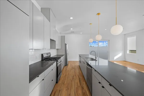 a kitchen with granite countertop a sink a counter space and cabinets
