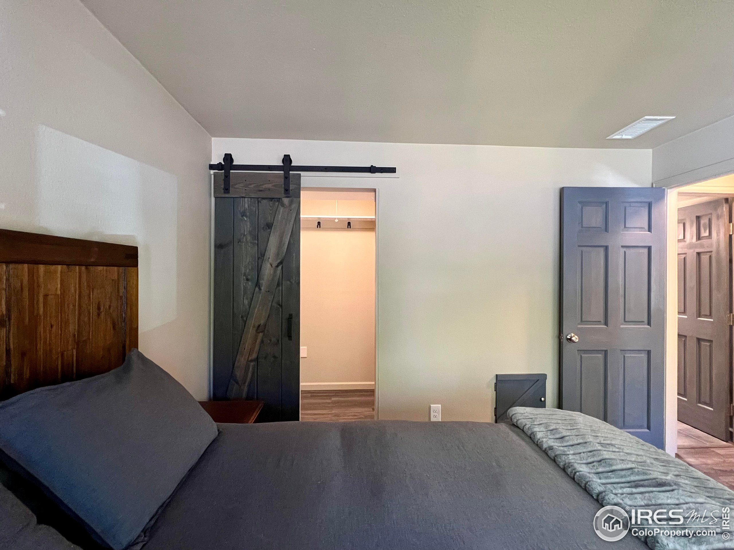 1705 Heatheridge Road, Unit M204 Fort Collins, CO 80526 - Photo 17 of 35 a bedroom with a bed and wooden floor