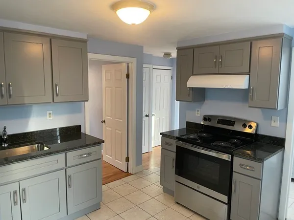 a kitchen with white cabinets and black appliances