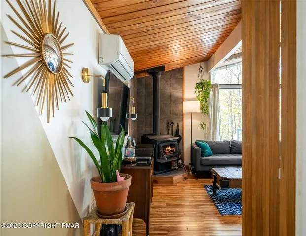 a living room with furniture floor to ceiling window and potted plants
