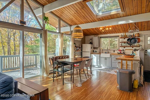 a dining room with wooden floor a glass table and chairs