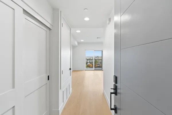 a view of a hallway with wooden floor