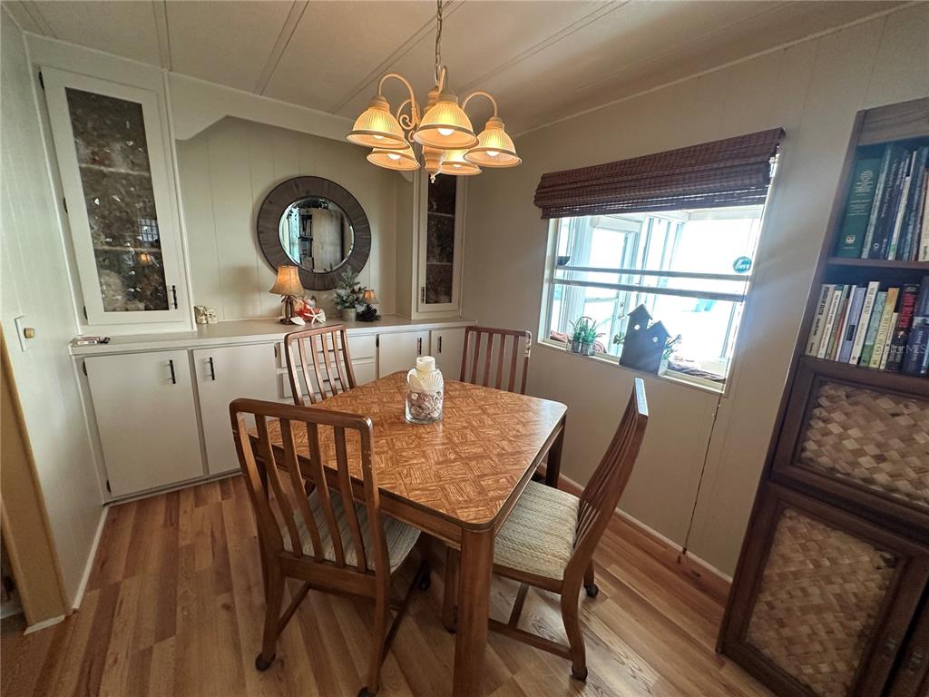 5800 Forsythia Road Venice, FL 34293 - Photo 4 of 27 a view of a dining room with furniture a chandelier and wooden floor