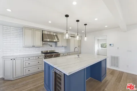 a kitchen with stainless steel appliances kitchen island granite countertop a stove and a sink
