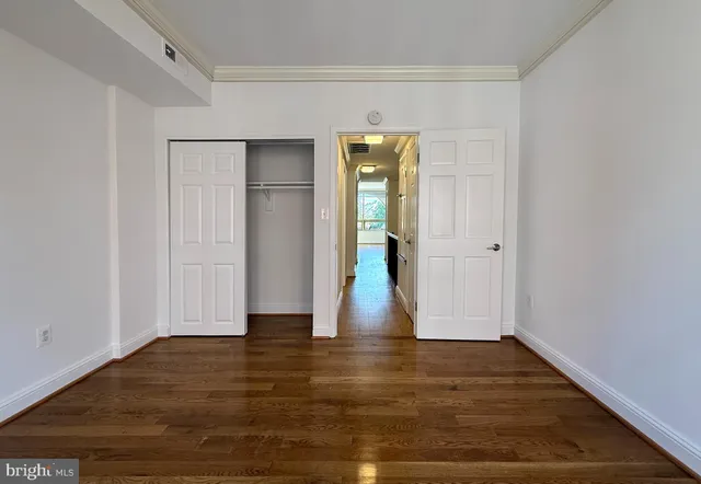 a view of empty room with wooden floor and entryway