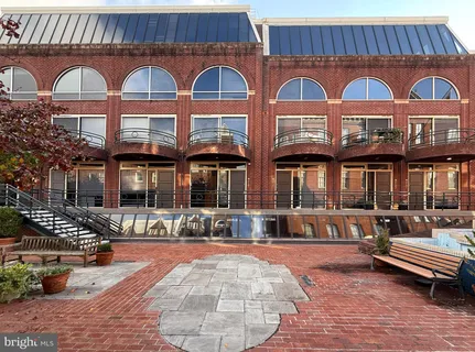 a front view of a brick building with many windows and a yard
