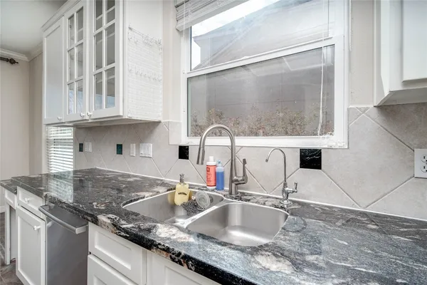 a kitchen with stainless steel appliances granite countertop a sink stove and white cabinets