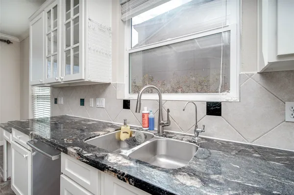 a kitchen with stainless steel appliances granite countertop a sink stove and white cabinets