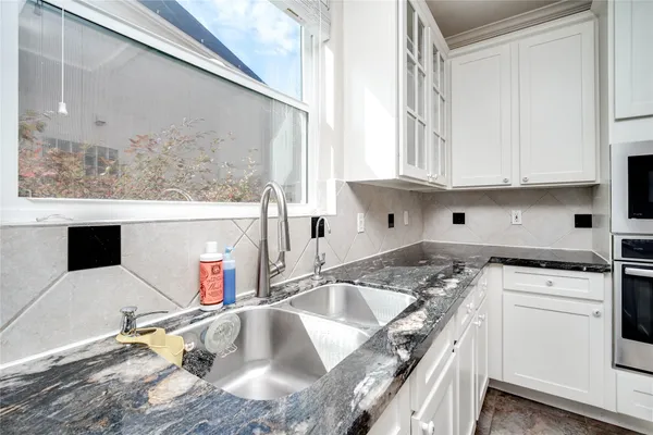 a kitchen with a refrigerator and white cabinets