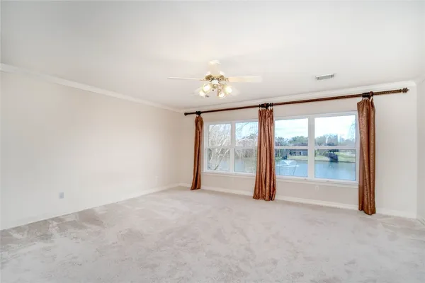 an empty room with chandelier fan
