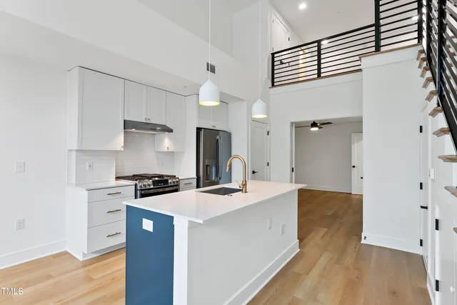 a kitchen with stainless steel appliances a sink a stove a refrigerator and cabinets