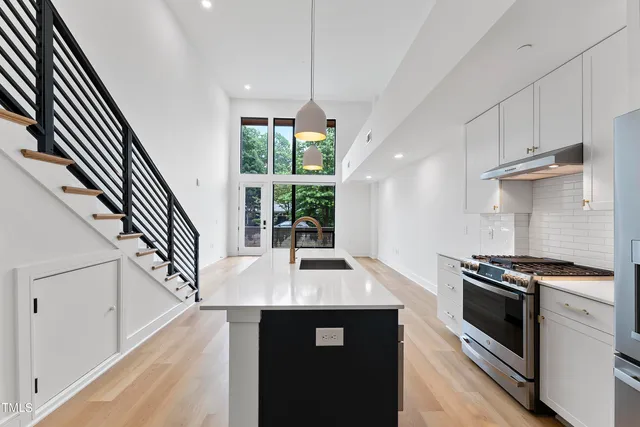 a kitchen with granite countertop a stove a sink and a refrigerator