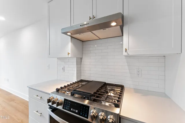 a stove top oven sitting inside of a kitchen