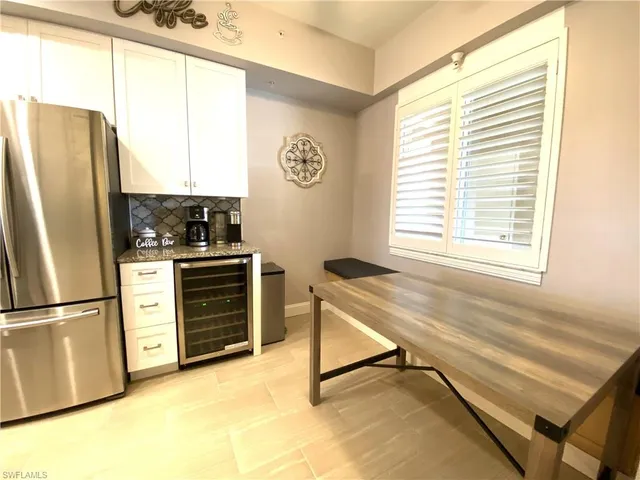 a kitchen with kitchen island granite countertop wooden floor and white cabinets