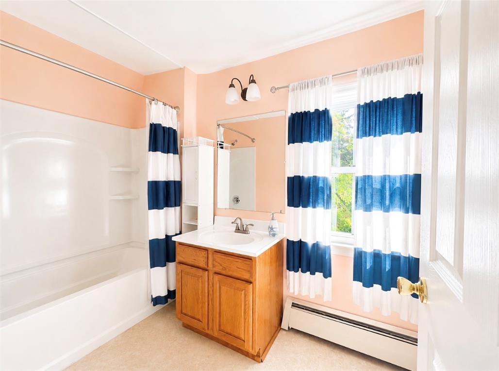 7281 Decatur Street New Tripoli, PA 18066 - Photo 16 of 27 A compact bath features a combined tub and shower unit and a window dressed with playful striped curtains.