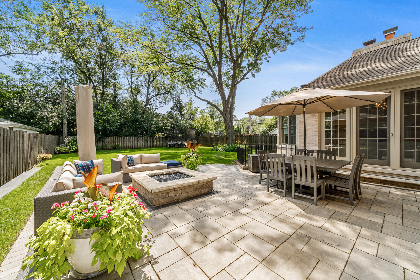 2235 Covert Road Glenview, IL 60025 - Photo 33 of 35 a view of a patio with a dining table and chairs under an umbrella with large trees