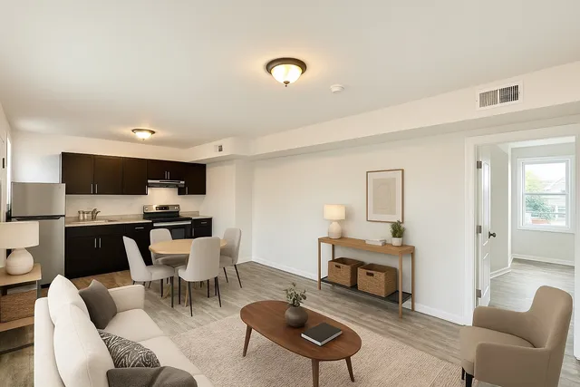 a living room with furniture a flat screen tv and kitchen view