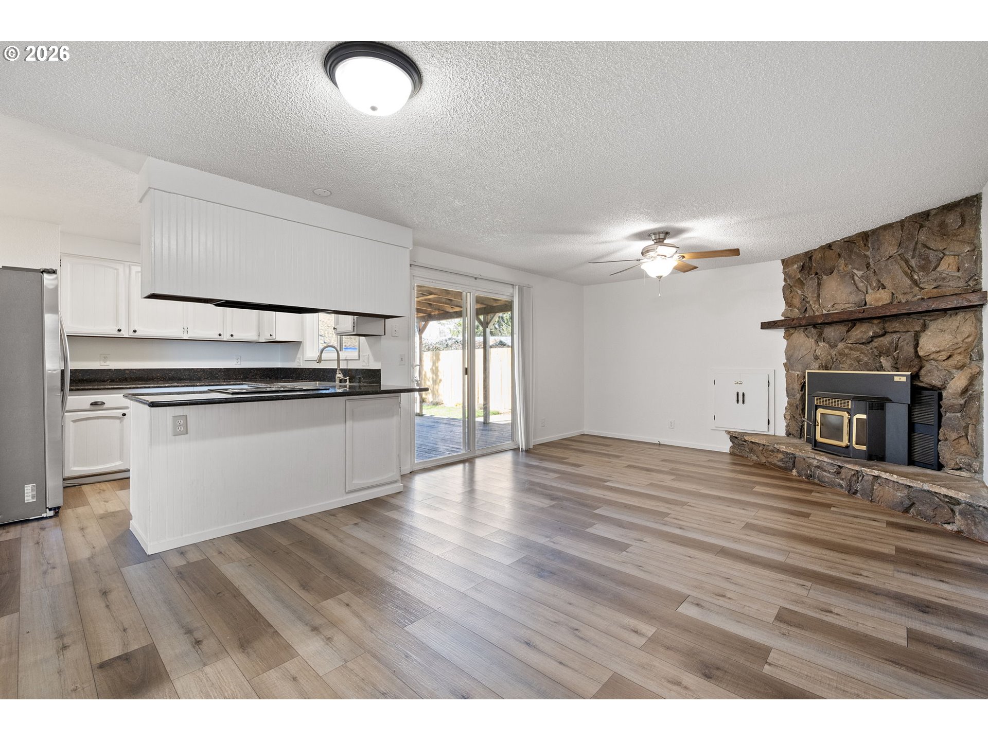 422 South 49th Place Springfield, OR 97478 - Photo 12 of 32 a view of kitchen and empty room with wooden floor