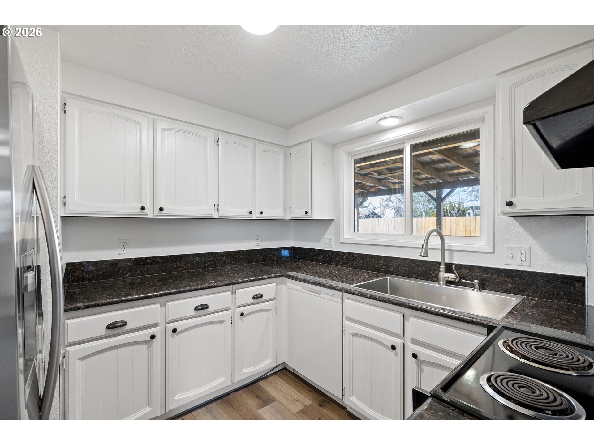 422 South 49th Place Springfield, OR 97478 - Photo 8 of 32 a kitchen with granite countertop a sink cabinets and window