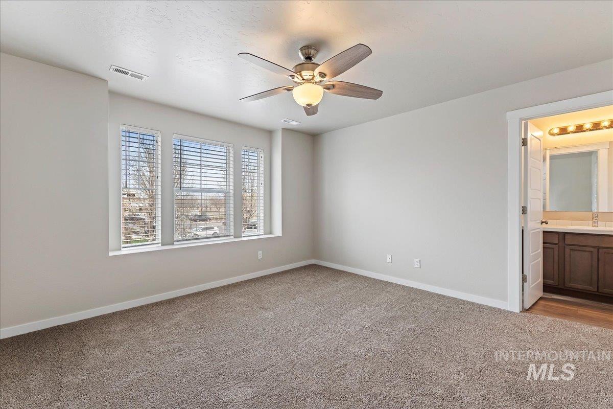 2517 East Goldstone Street Meridian, ID 83642 - Photo 11 of 22 Unfurnished bedroom featuring light carpet, a ceiling fan, and ensuite bathroom