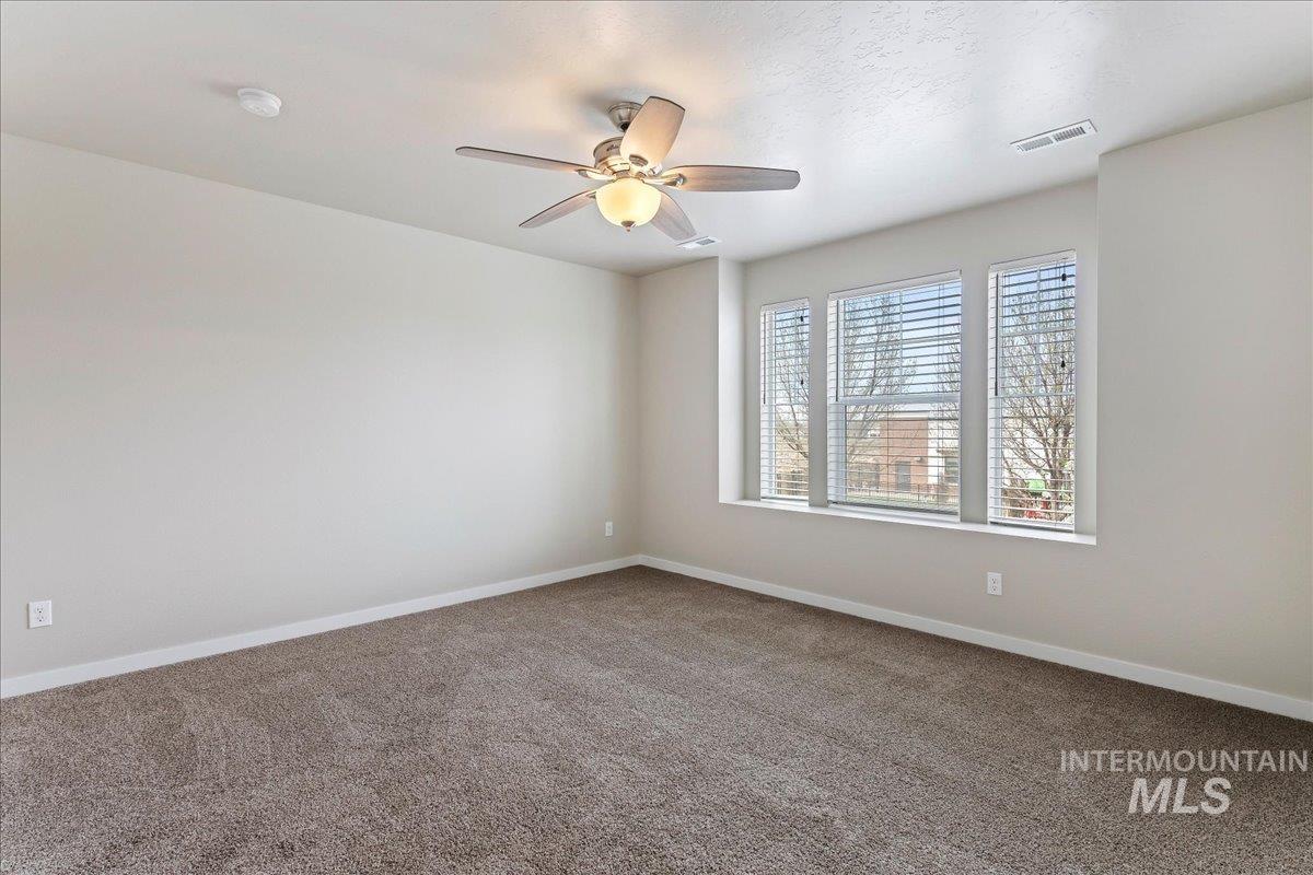 2517 East Goldstone Street Meridian, ID 83642 - Photo 12 of 22 Spare room with dark carpet and ceiling fan