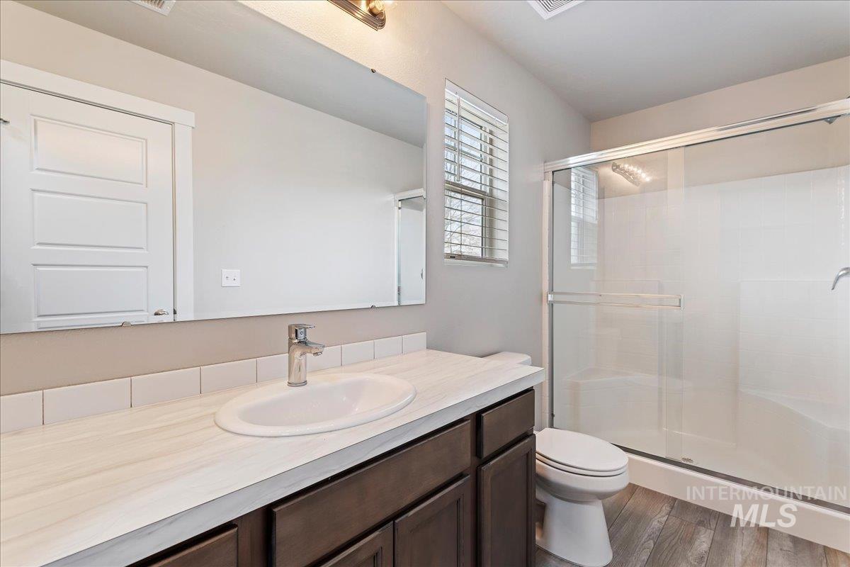 2517 East Goldstone Street Meridian, ID 83642 - Photo 15 of 22 Bathroom with a shower stall, vanity, and dark wood-type flooring