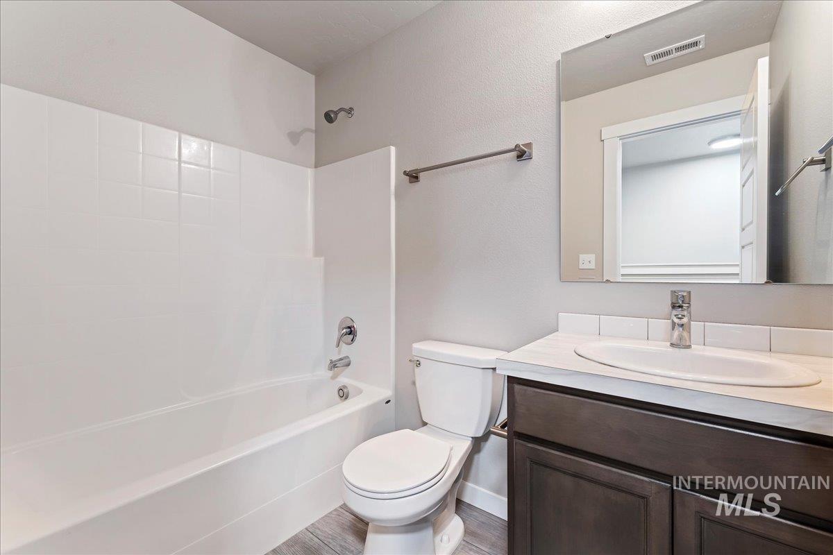 2517 East Goldstone Street Meridian, ID 83642 - Photo 16 of 22 Bathroom with vanity, shower / bathtub combination, wood finished floors, and a textured wall