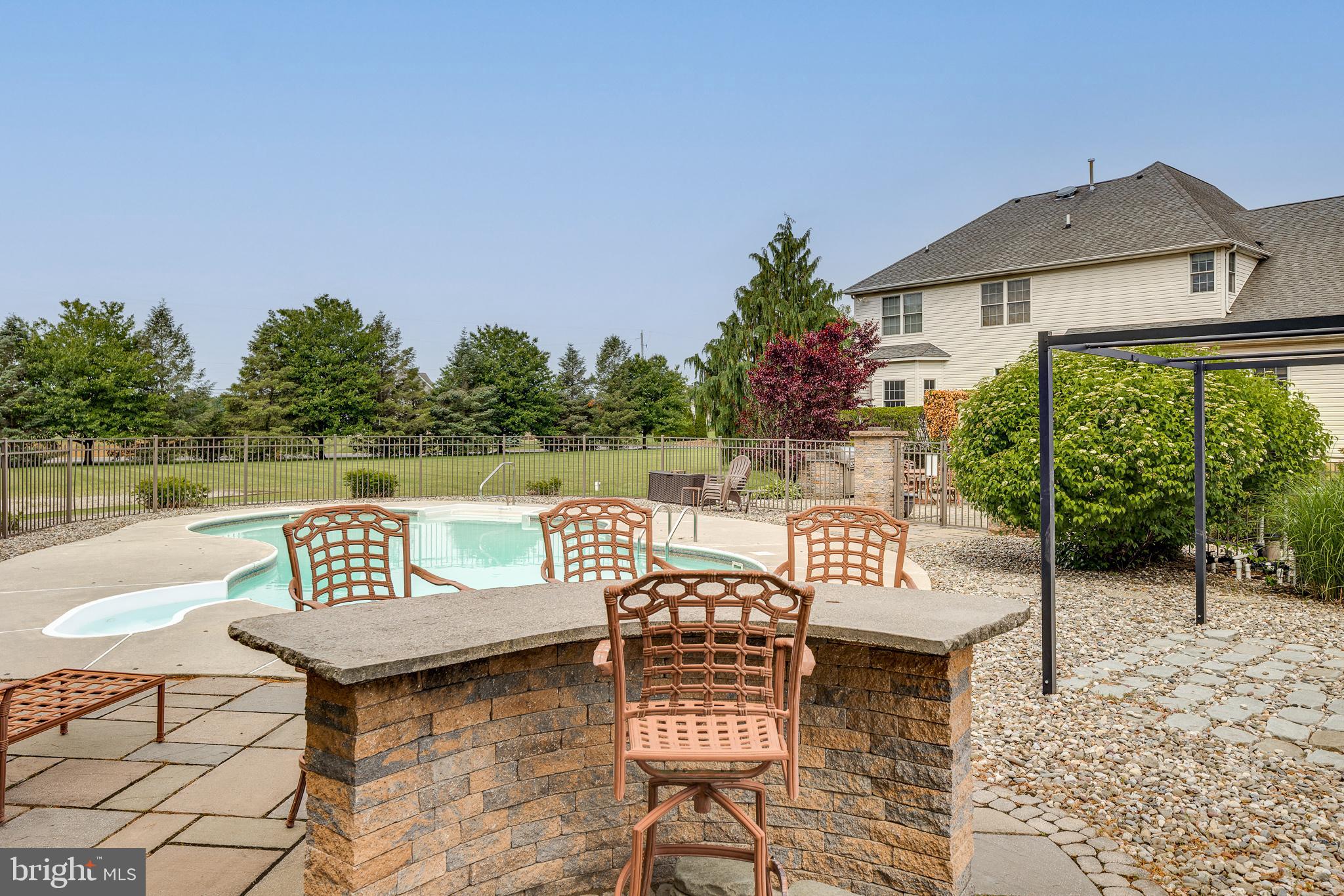 2 Dellaira Court Wrightstown, NJ 08562 - Photo 72 of 93 a view of a patio with couches table and chairs under an umbrella with a lake view