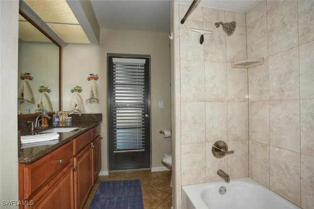 a bathroom with a granite countertop sink a mirror a bathtub and shower