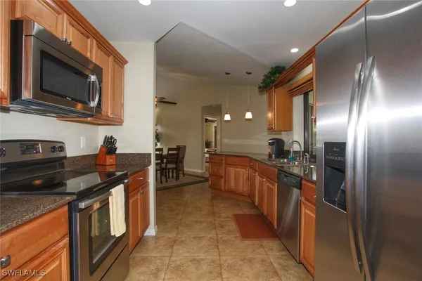 a kitchen with stainless steel appliances granite countertop a stove a sink and a microwave
