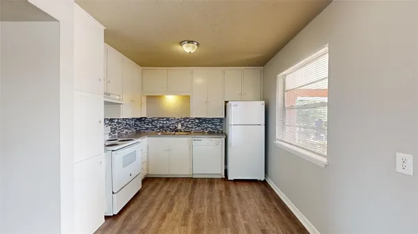 a kitchen with granite countertop white cabinets and white appliances