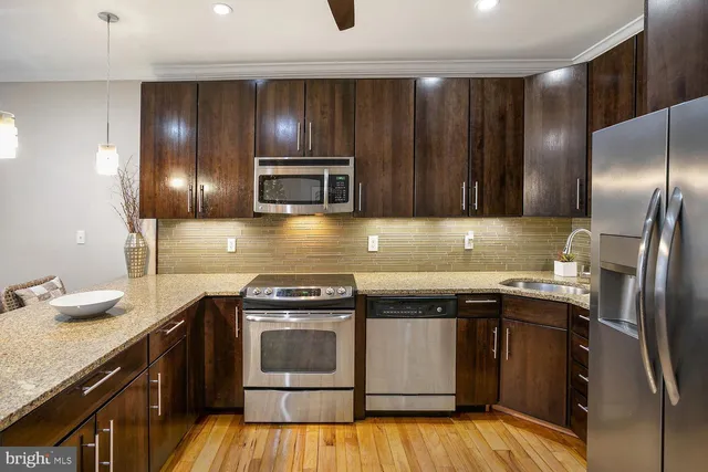 a kitchen with granite countertop stainless steel appliances and wooden cabinets