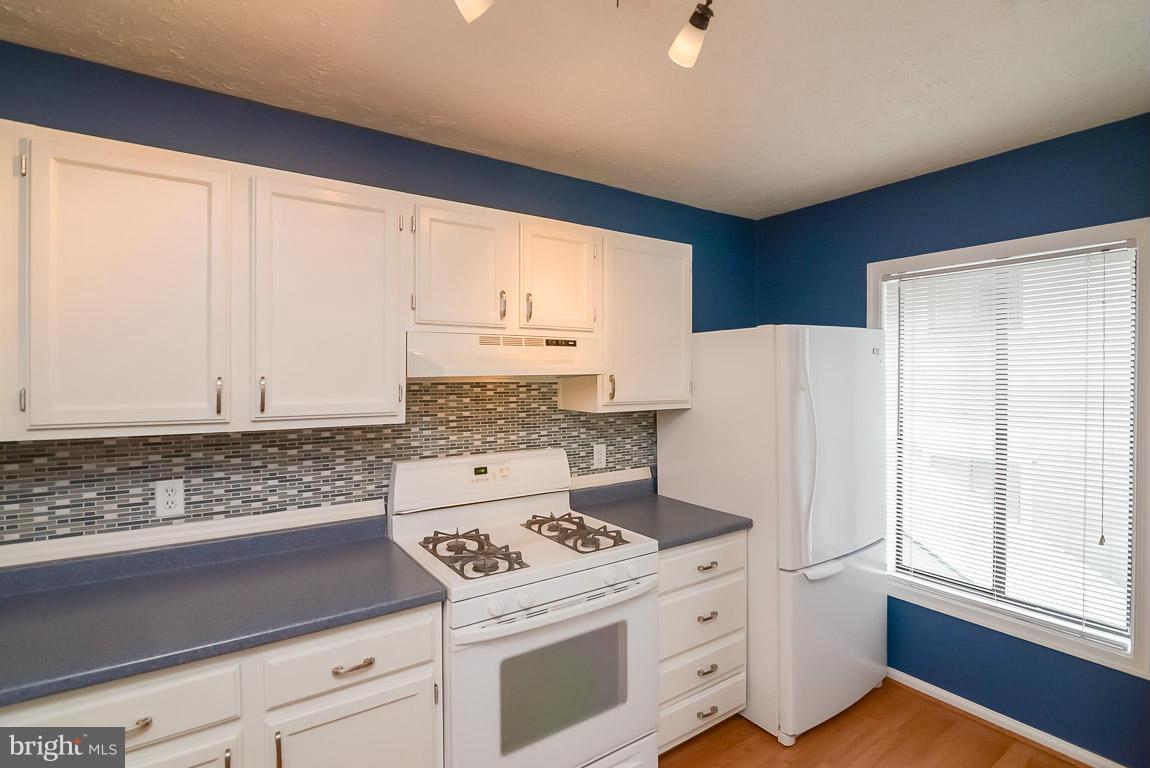 2253 Hunter's Run Drive, Unit 2253 Reston, VA 20191 - Photo 11 of 25 a kitchen with a white cabinets and white appliances