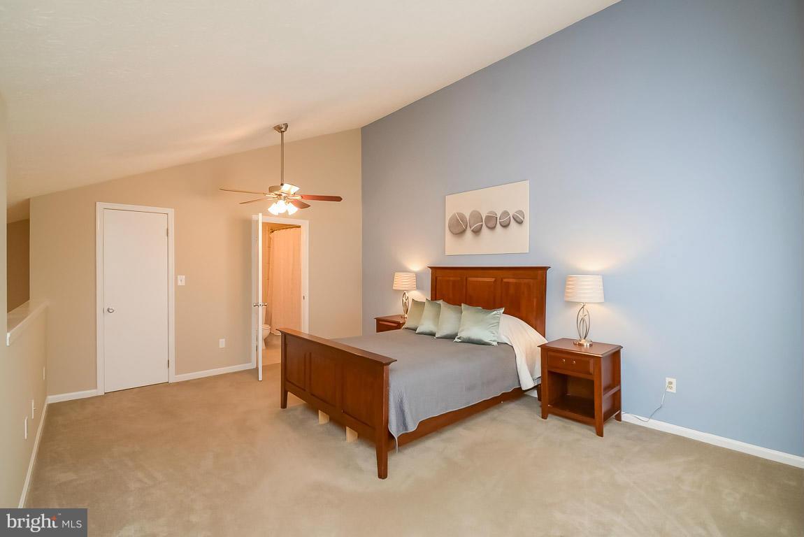 2253 Hunter's Run Drive, Unit 2253 Reston, VA 20191 - Photo 12 of 25 a bedroom with a bed and a lamp
