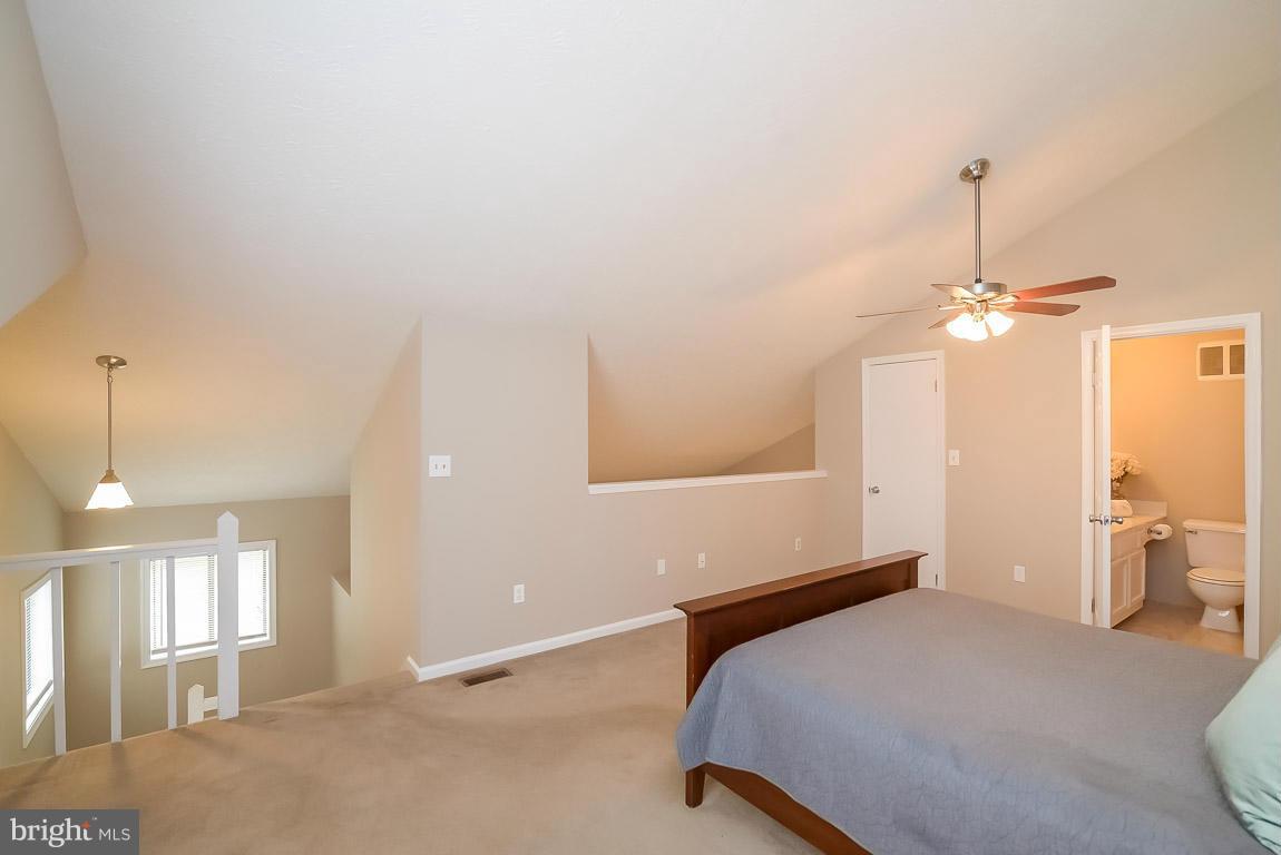 2253 Hunter's Run Drive, Unit 2253 Reston, VA 20191 - Photo 14 of 25 a bedroom with a bed chandelier and a window