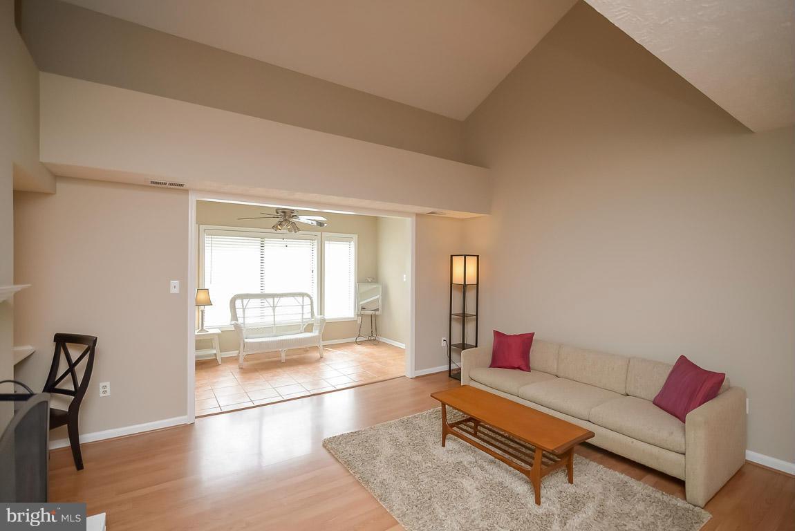 2253 Hunter's Run Drive, Unit 2253 Reston, VA 20191 - Photo 4 of 25 a living room with furniture and a floor to ceiling window