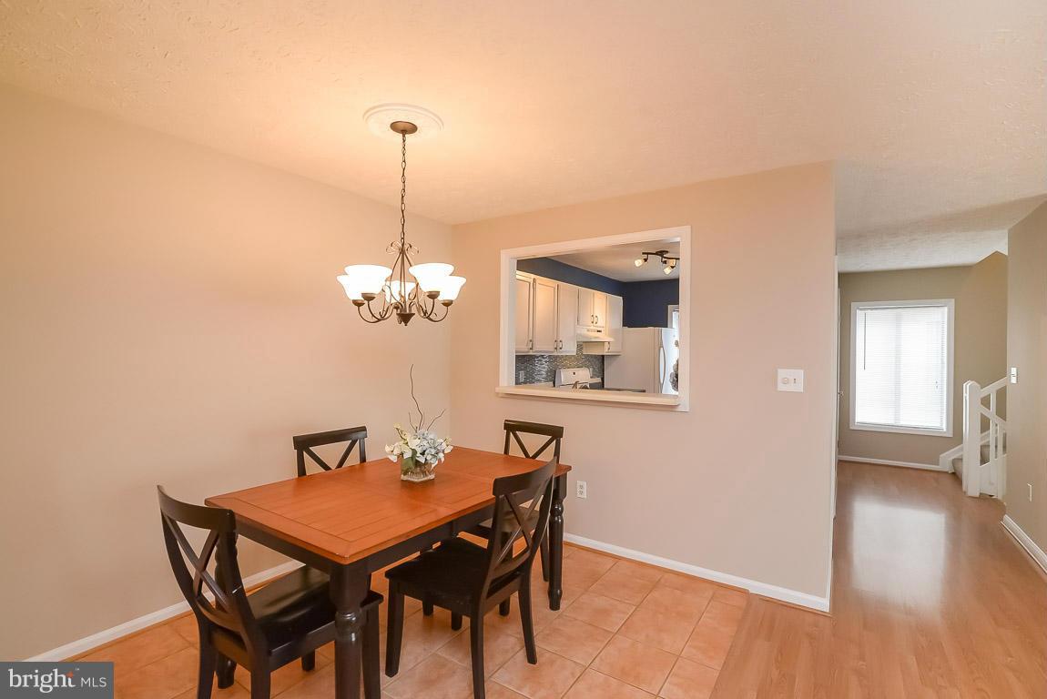 2253 Hunter's Run Drive, Unit 2253 Reston, VA 20191 - Photo 7 of 25 a dining room with furniture and wooden floor