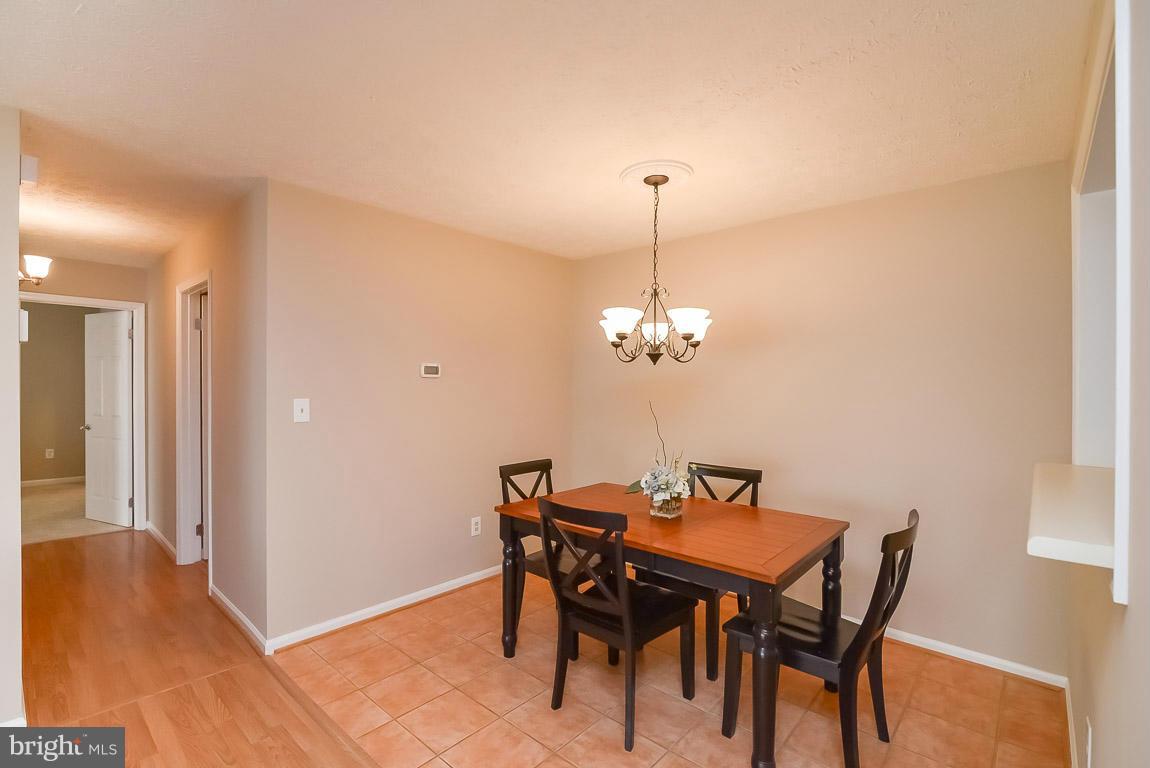 2253 Hunter's Run Drive, Unit 2253 Reston, VA 20191 - Photo 8 of 25 a view of a dining room with furniture and chandelier