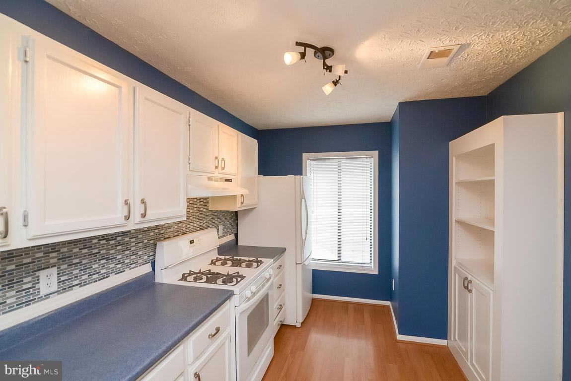 2253 Hunter's Run Drive, Unit 2253 Reston, VA 20191 - Photo 10 of 25 a kitchen with a stove a sink and a refrigerator