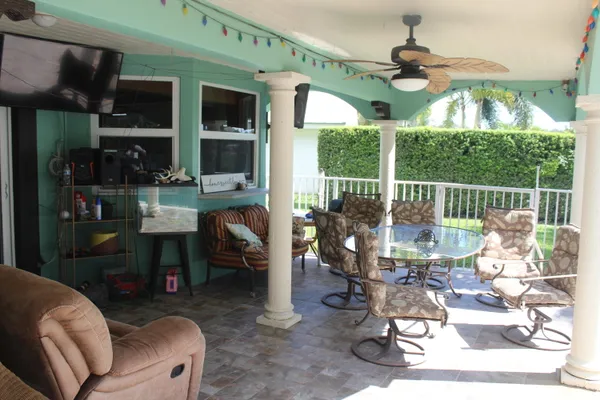 a living room with patio furniture and a chandelier